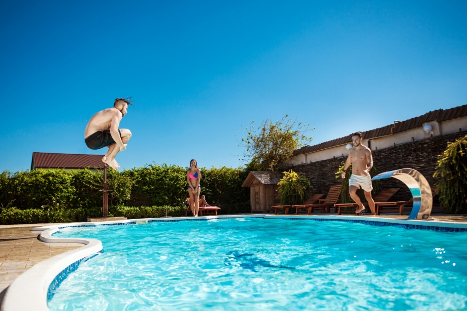 Jovens alegres pulando piscina cristalina